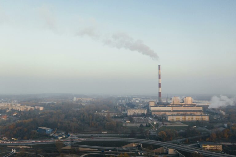 Aerial shot of a power plant emitting smoke, highlighting urban air pollution and industrial impact.